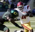 Joe McKnight looks for running room against Oregon defender Walter Thurmond. (AP Photo/Don Ryan)