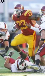 USC's Chauncey Washington (23), center, runs past several Stanford defenders during the second quarter. (AP Photo/Matt Sayles)
