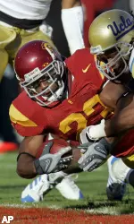 USC running back Chauncey Washington, left, scores a touchdown as UCLA safety Chris Horton (14) and cornerback Trey Brown defend during the first half. (AP Photo/Mark J. Terrill)