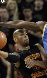 USC's Taj Gibson, left, looks to pass the ball under pressure from UCLA's Alfred Aboya (12) during the first half (AP Photo)
