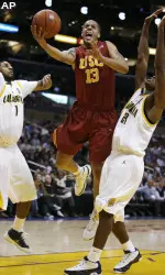 Daniel Hackett splits a pair of Cal defenders on his way to the hoop. (AP Photo/Danny Moloshok)