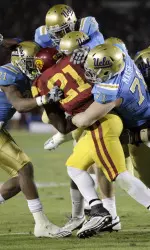 AP - Southern California running back Allen Bradford(21) is defended by UCLA players during the first half.