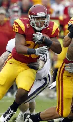 Southern California's Marc Tyler, left, completes a first down as Washington's Everrette Thompson (92) defends during the first half.