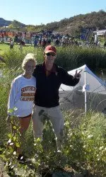 Not illness or Mother Nature could slow the Trojans down today at the Pac-12 Cross Country Championships. Here Shelby Buckley and Coach Tom Walsh pose in front of the team's tent which ended up in a water hazard due to the high winds on the course.