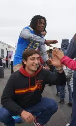 UCLA's Jayon Brown and USC's Anthony Neyer greet children.