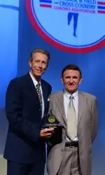 Former Director of Track & Field Ron Allice receives his Hall of Fame Award from Dwight Stones, one of the many Olympians he coached.