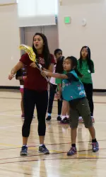Freshman Nina Kelty offers lacrosse tips to a local Girl Scout.