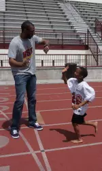 D.J. Haley of Men's Basketball coaches kids around Loker Stadium.