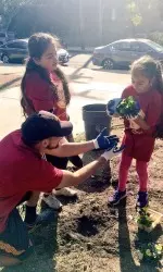 Trojans paired with 186th Street students to complete gardening, painting and other beautification tasks.