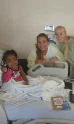 Sophomores Paige Hines (middle) and Sara Hughes (right) pose with a young patient at Children's Hospital Los Angeles.
