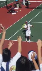 USC women's tennis associate head coach West Nott blasts tennis balls into the swarming crowd at Saturday's Girls PLAY event.