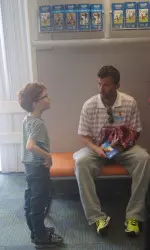 USC men's tennis Associate Head Coach Krzysztof Kwinta holds a conversation with a young boy at Children's Hospital Los Angeles.