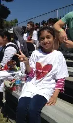 A Girls PLAY attendee cheers on the Trojan lacrosse team.