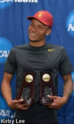 Andre De Grasse holds his 100m and 200m champion trophies.