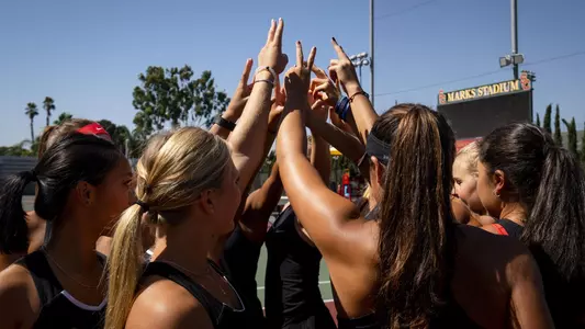 The USC Women's Tennis raises "fight on" signs.