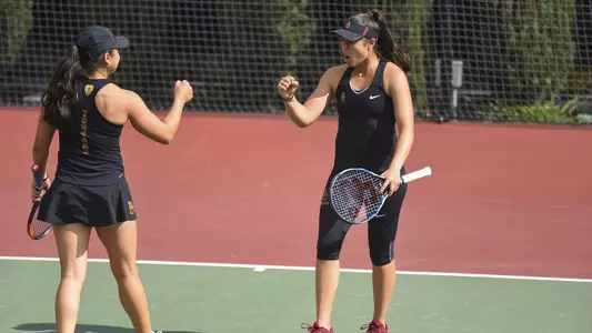 Angela Kulikov and Rianna Valdes fist bump after scoring a point.
