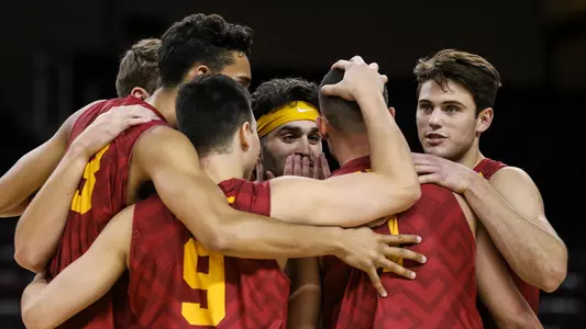 The USC Men's Volleyball team huddles together on the court after a point.