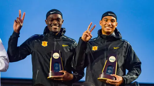 Benjamin & Norman Holding NCAA Trophies