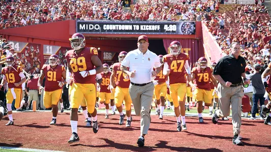 USC football coach Clay Helton runs the Trojans out of the L.A. Coliseum tunnel