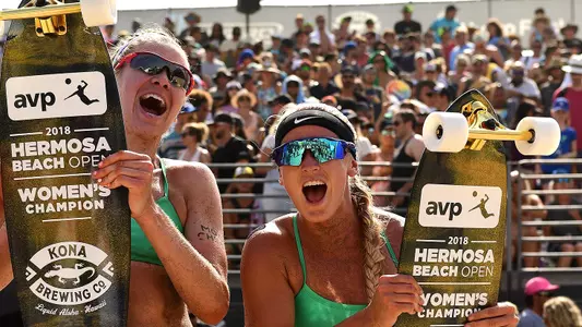 Sara Hughes and Summer Ross hold up their skateboard trophies after winning the 2018 AVP Hermosa Beach Open.