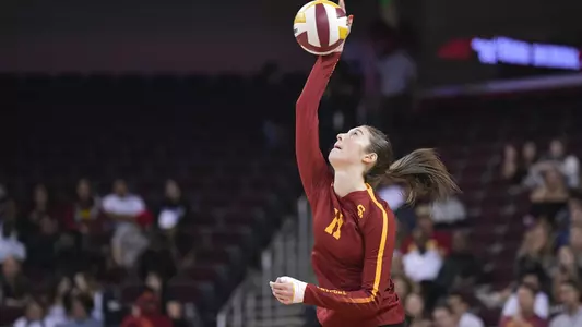 Women's volleyball middle blocker Jasmine Gross serves the ball.