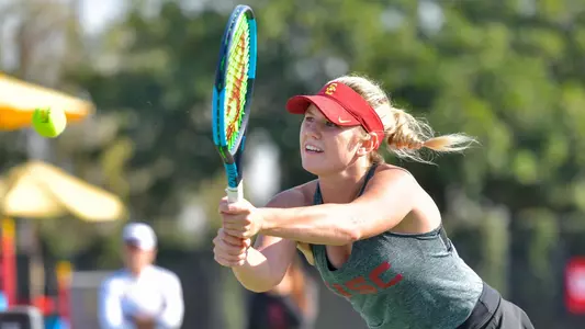 Constance Branstine reaches out with her racquet to hit the ball.