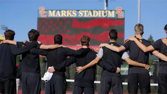 The USC team stands for the playing of the National Anthem at Marks Stadium