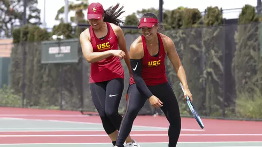 Angela Kulikov and Rianna Valdes smile after scoring a point in doubles.