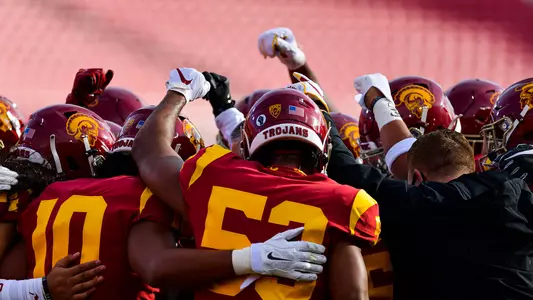 USC Trojans Football players and coaches huddle