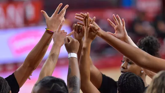 USC players raise their hands for a huddle at Galen Center