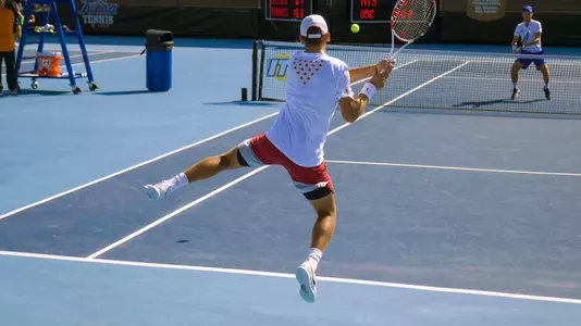 Stefan Dostanic hits a jumping backhand down the line during ITA All-American doubles competition