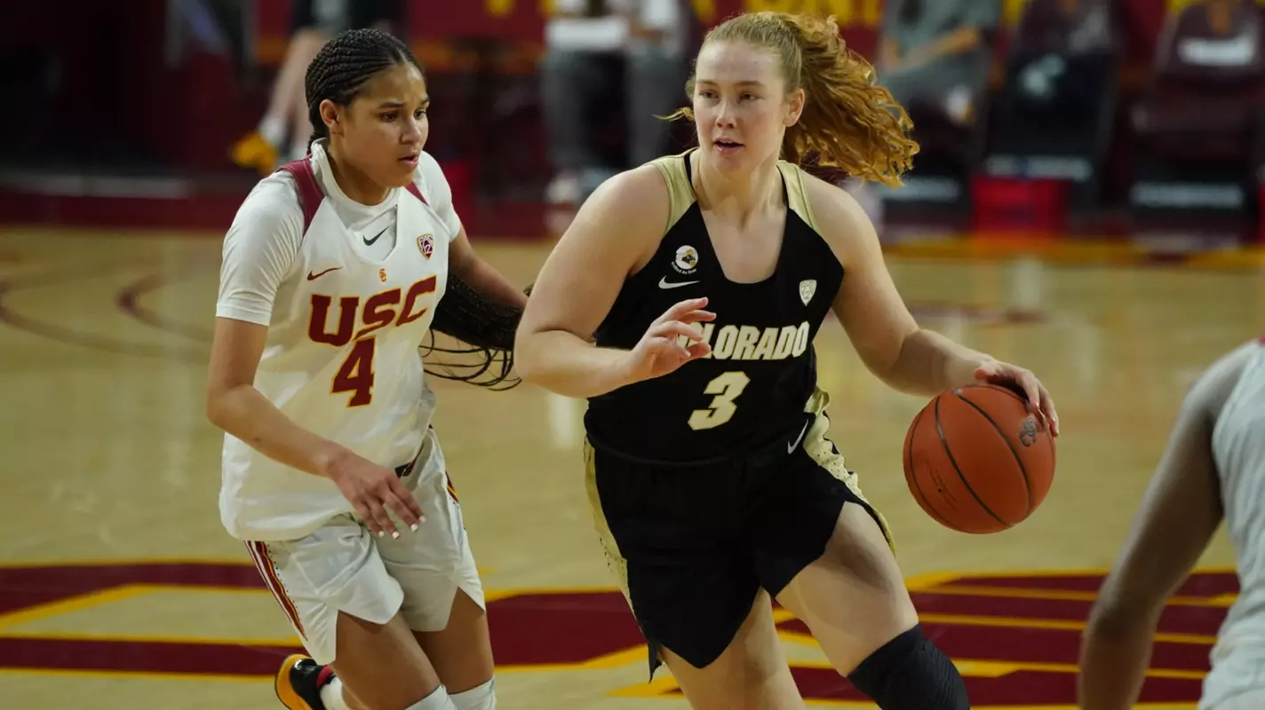 A Colorado player drives against the USC defense at Galen Center