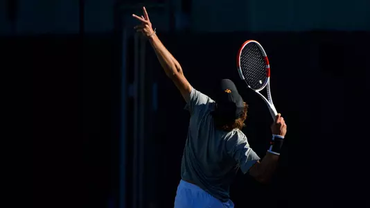 Stefan Dostanic serves with the sun at his back at Marks Stadium
