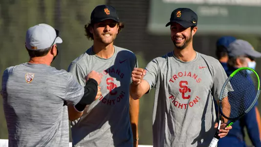 USC doubles pair Stefan Dostanic and Mor Bulis are congratulated by coach Brett Masi