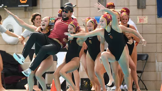 Marko Pintaric jumps into the pool with players after USC's 2021 NCAA championship win at UCLA