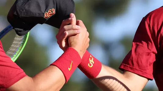 Trojans clasp hands during a match