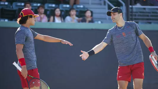 Doubles pair Bradley Frye and Stefan Dostanic give each other five during a match at Marks Stadium