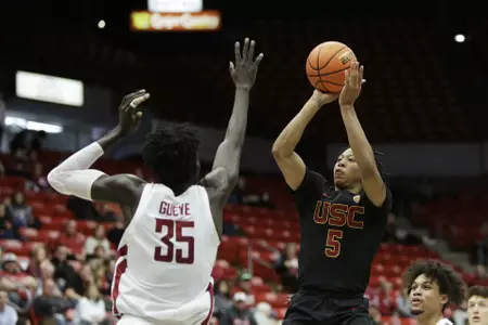 Southern California guard Boogie Ellis (5) shoots while defended by Washington State forward Mouhamed Gueye (35) during the second half of an NCAA college basketball game, Sunday, Jan. 1, 2023, in Pullman, Wash. Washington State won 81-71. (AP Photo/Young Kwak)
