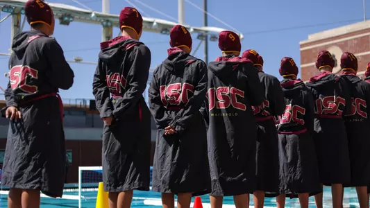 USC team members line up poolside for the National Anthem