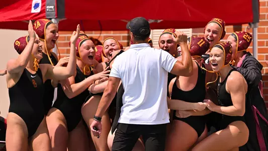 USC coach Marko Pintaric and his team cheer together after a win over Stanford at Uytengsu Aquatics Center
