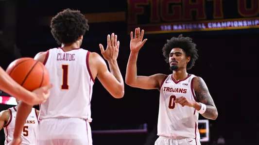 Desmond Claude and Saint Thomas high five after a basket