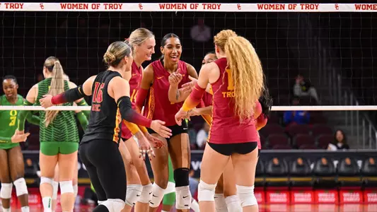 The Trojans huddle in the middle of the court during a women's volleyball match against Oregon