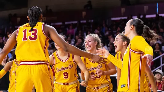 USC players celebrate together at Galen Center