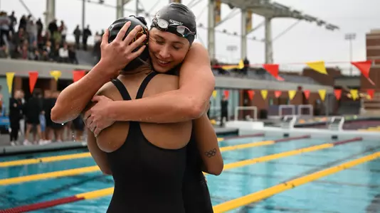 Minna Abraham and Anicka Delgado hug after winning 400y free relay against Stanford