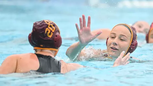Julia Janov and Meghan McAninch give each other five during a game at Uytengsu Aquatics Center