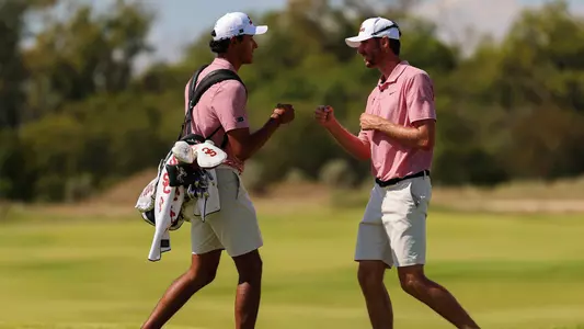 USC Men's Golf's Nico Dominguez and Luke Stock fist bump during a round.