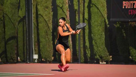 Dani Borruel attempts a backhand shot on tennis court.