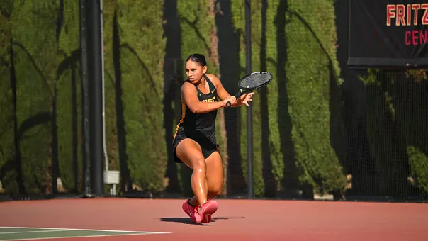 Dani Borruel attempts a backhand shot on tennis court.