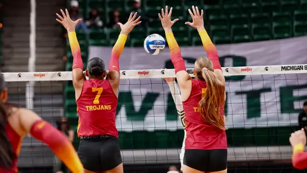USC women's volleyball middle blocker Leah Ford and opposite hitter Abigail Mullen go up to block a Michigan State attack during a match in Breslin Center.