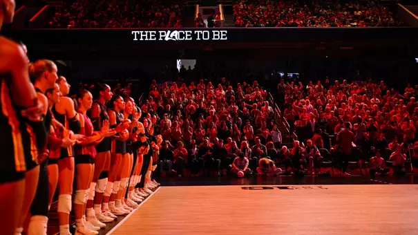 USC women's volleyball players line up for player intros during a match against Nebraska at the Galen Center with "The Place to Be" on the ribbon board displayed
